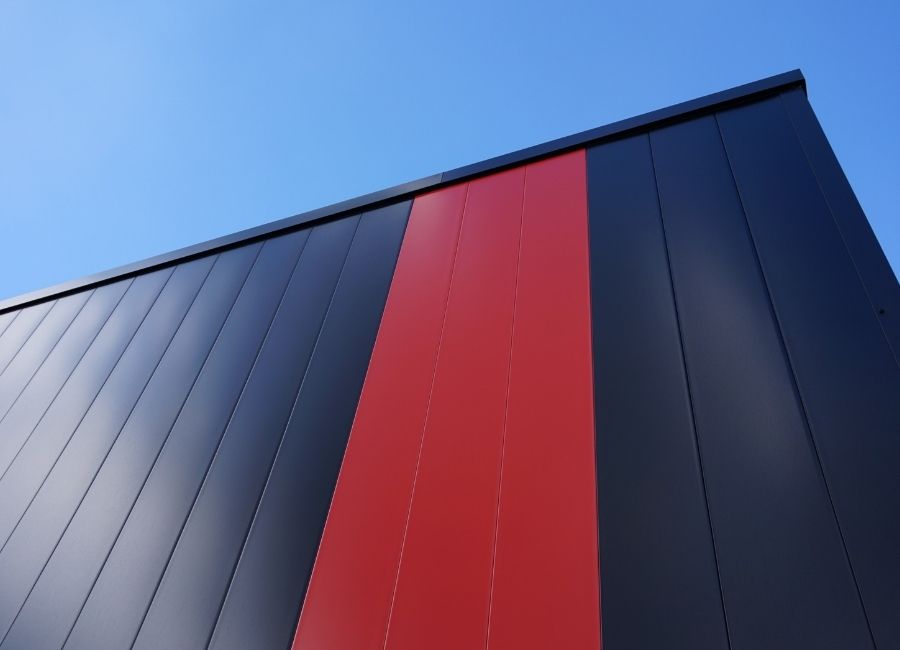 Zoom sur bardage métallique alternant les couleurs rouge et noire.