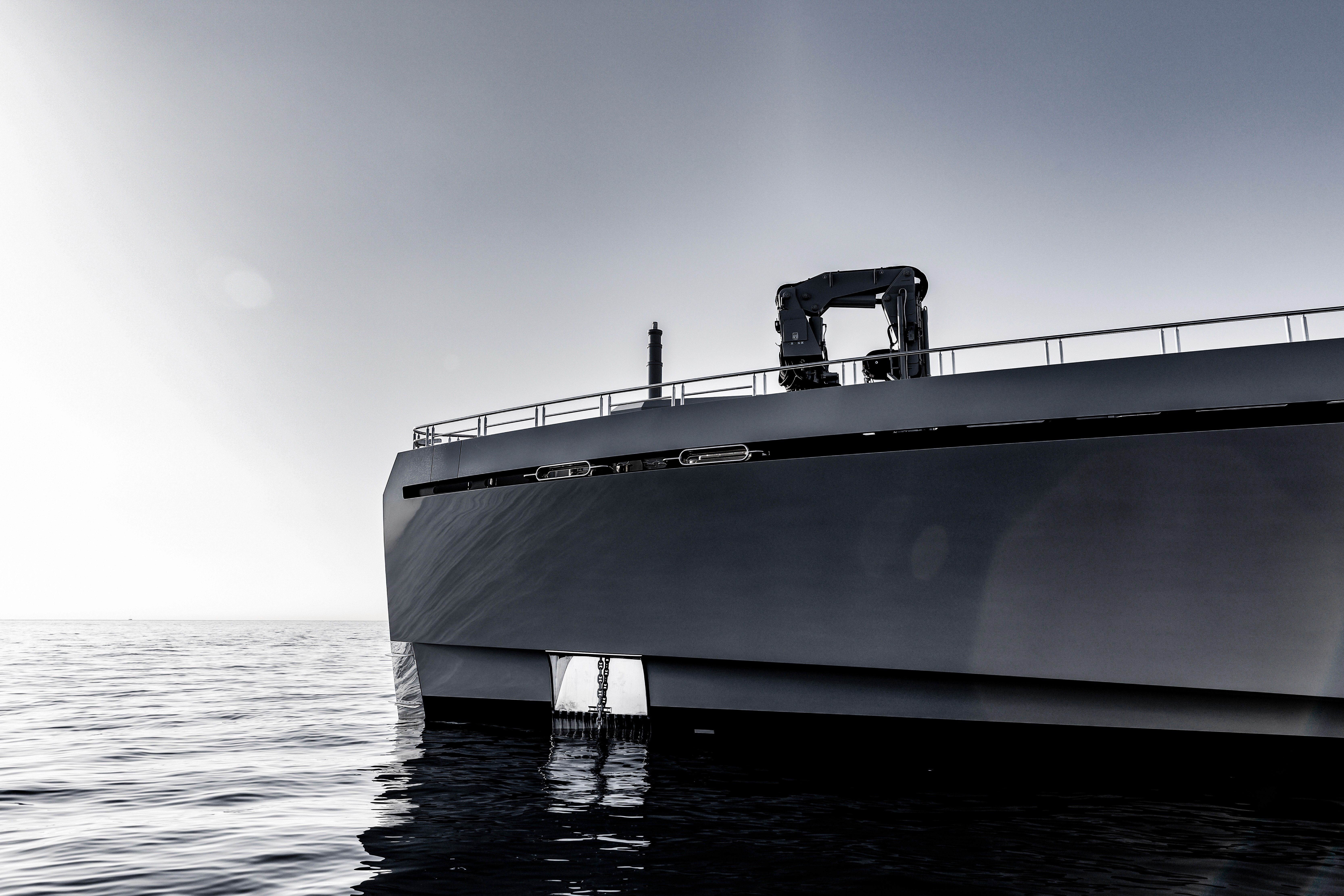 Sunlit orange armchair beside sheer curtains, wooden floor.