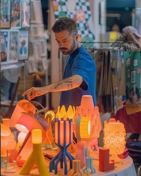 Zdjęcie przedstawiające projektanta lamp oraz jego produkty.