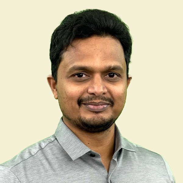 Man with arms crossed in modern office workspace.