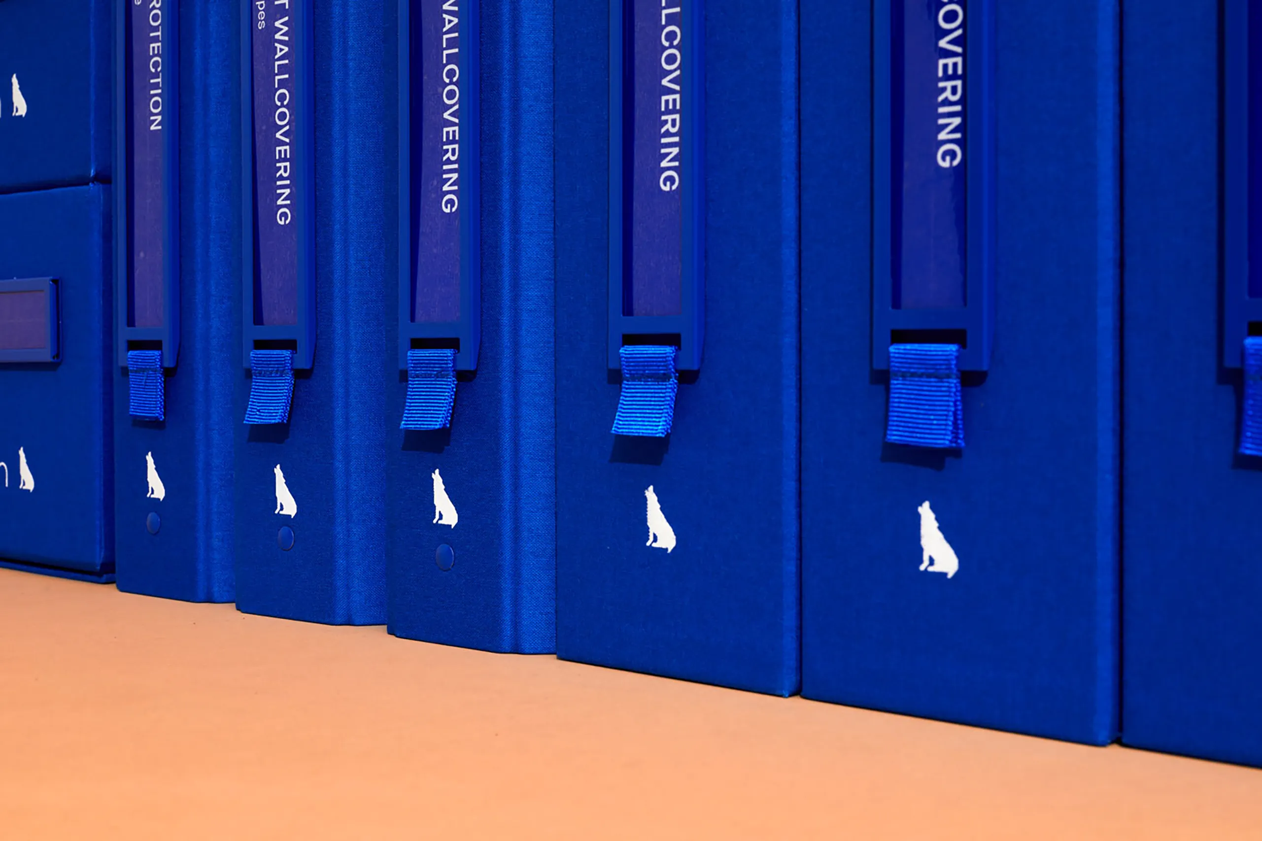 Close-up of blue Wolf-Gordon material sample binder spines and pull tabs
