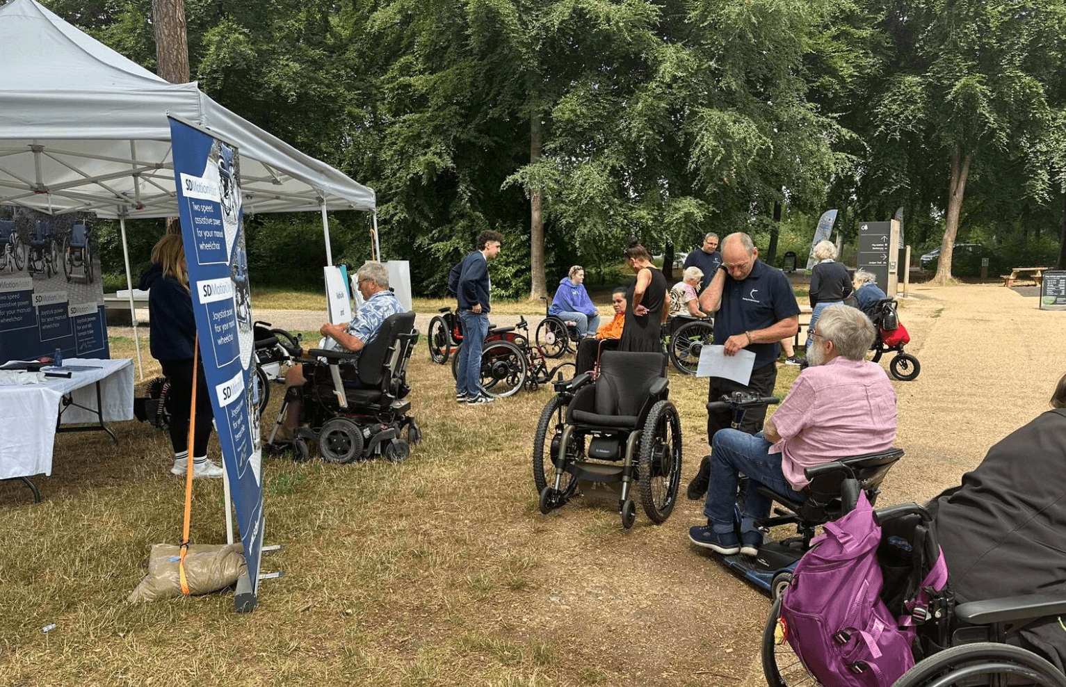 Group of staff and visitors looking at wheelchairs during our SD Motion coffee morning