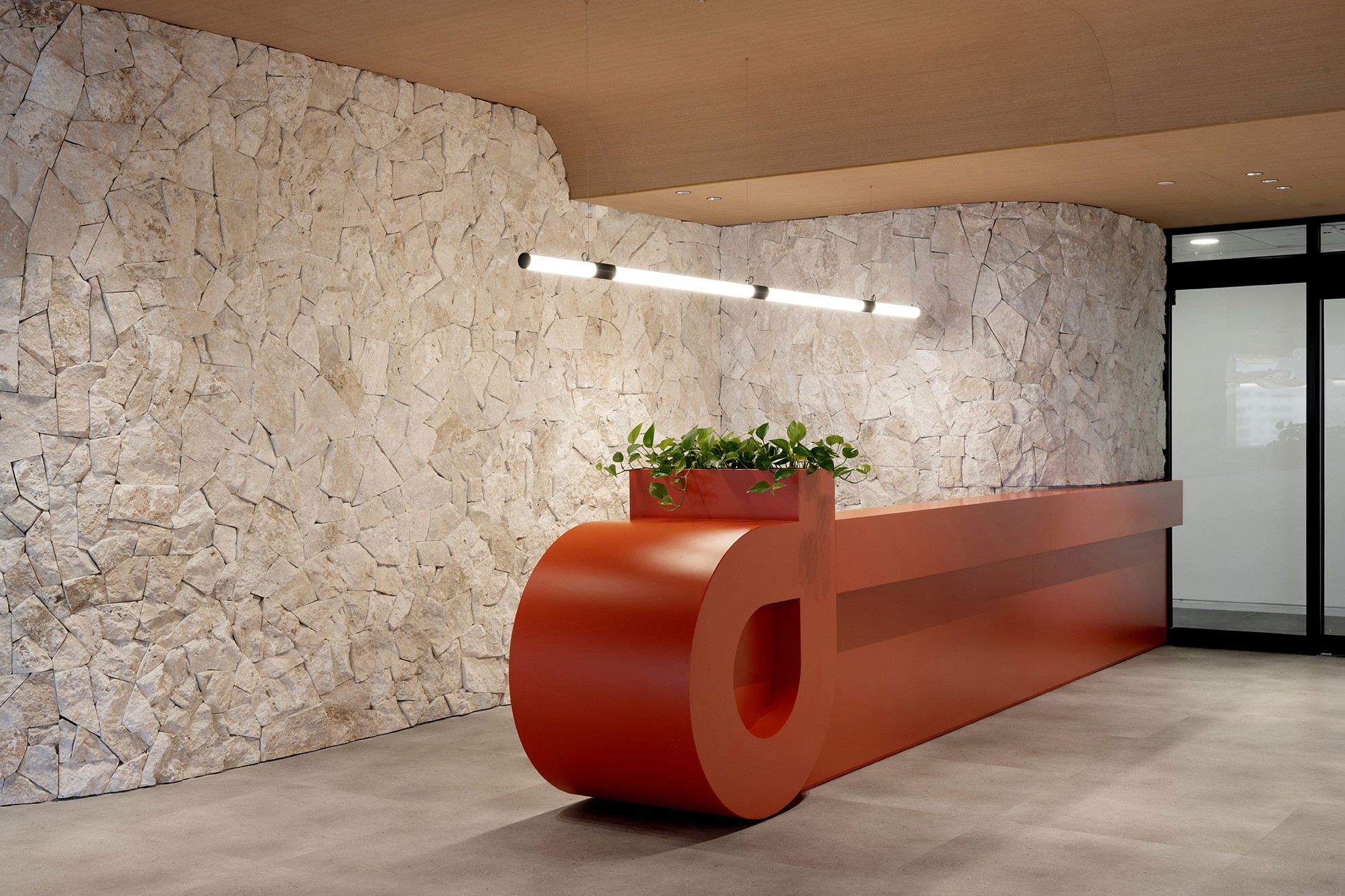 תרגום לוגו החברה לאלמנט בנוי – דלפק קבלה בנגרות Custom Made בצורת סמל המותג, צבוע באפוקסי אדום