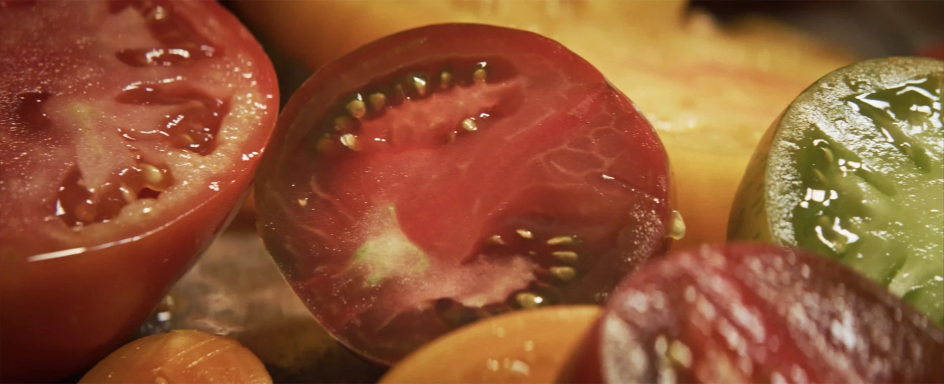 Amoris Pomum para Nowness: segundo fotograma de contenido multimedia que muestra fotograma con tonos verdes y rojos en una escena botánica.
