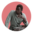 Circular portrait of a thoughtful African-American man, wearing a green button-down shirt, looking to the side.