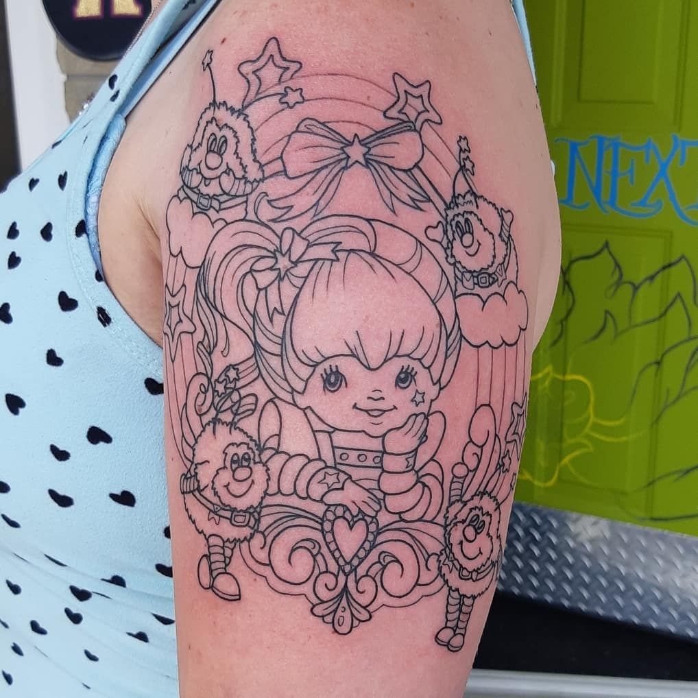 Colour cartoon girl tattoo on an upper arm