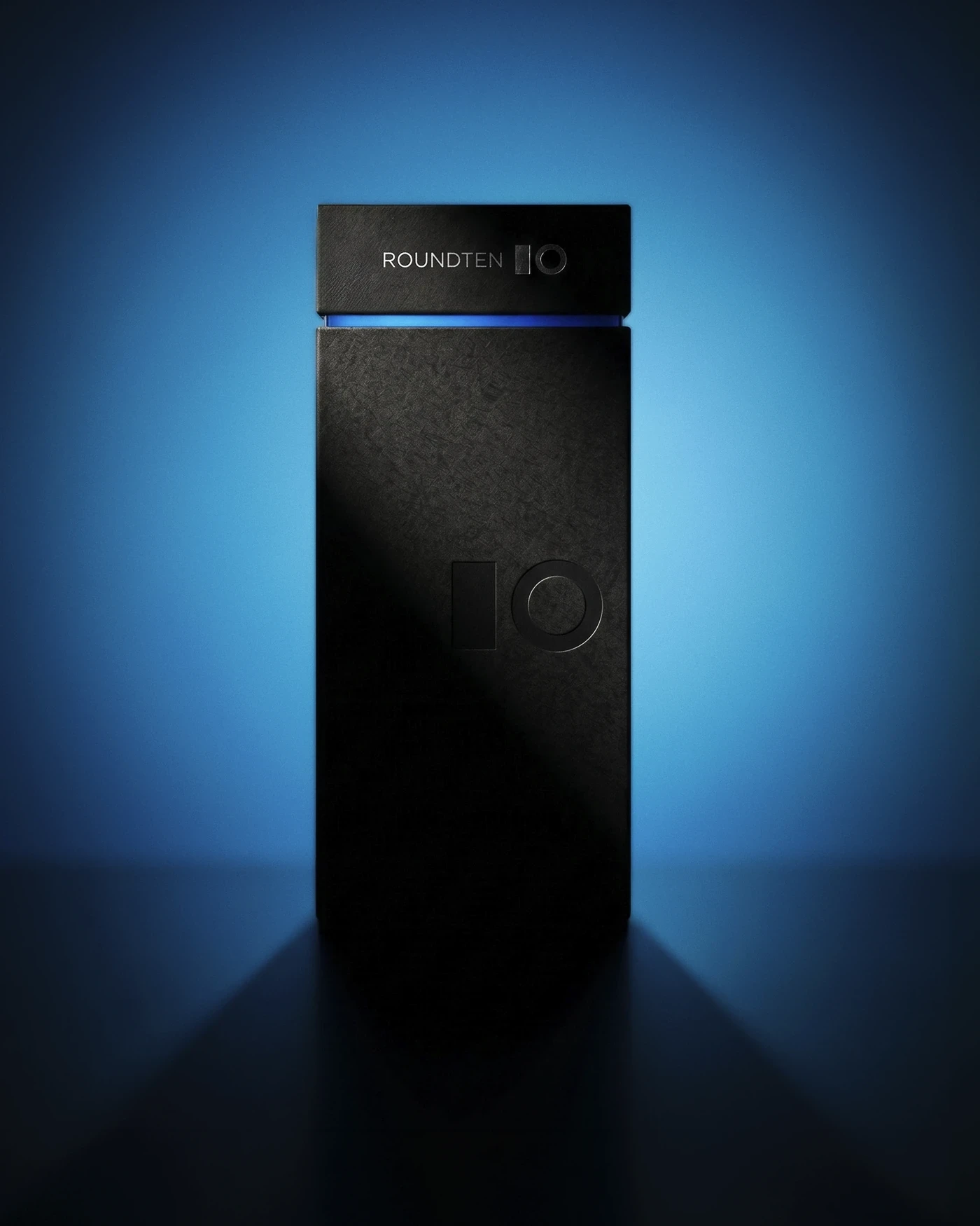 Tall matte black Roundten totem box with a blue hot-stamped line, backlit in blue, packaging design by Sebastian Saavedra
