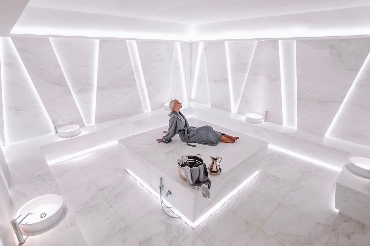 Black-and-white party photo of a smiling man in a check blazer among a crowd.