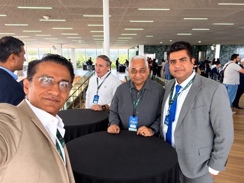 Zia Saeed, Founder and Chief Growth Officer of Fibonacci Agency, with three fellow attendees wearing conference lanyards around a high-top table in the open event hall at the OPEN Houston Conference