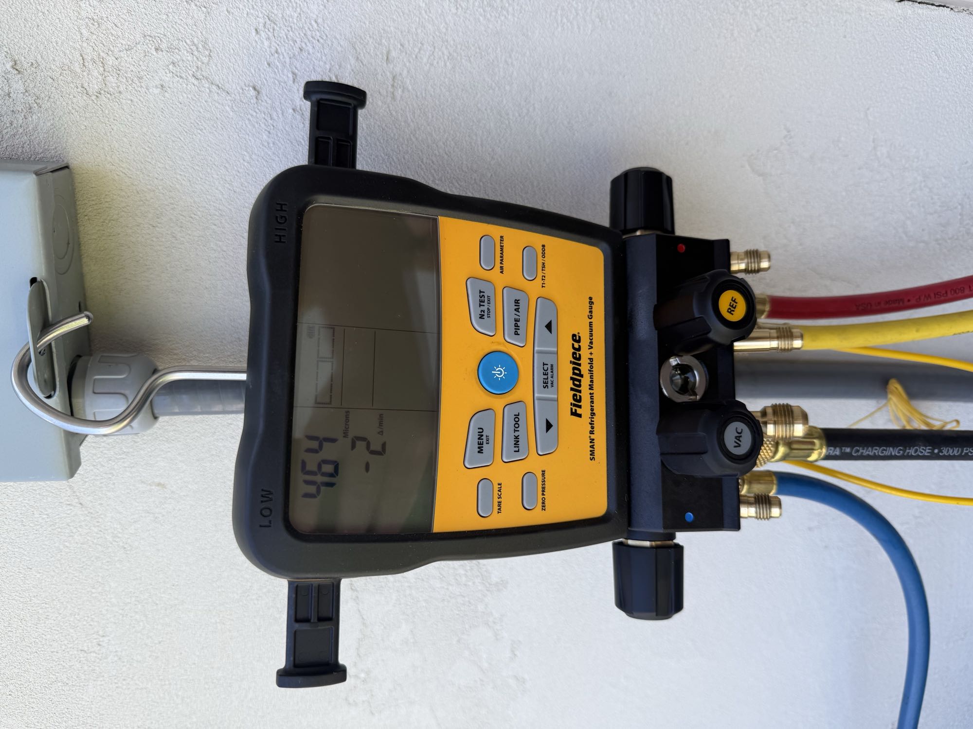Digital vacuum gauge reading 464 microns with a falling rate during the decay test after a leak repair.