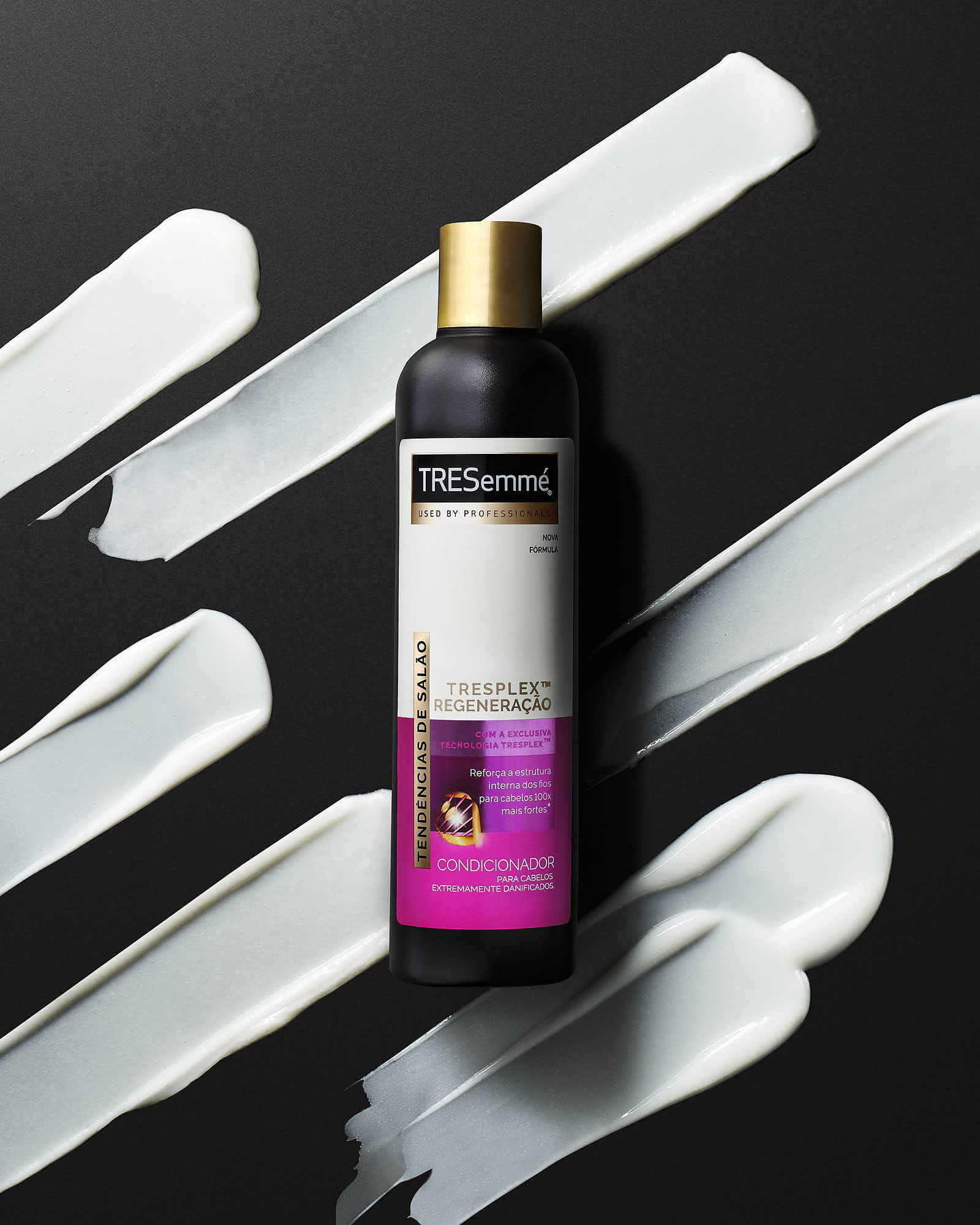 A spray bottle with a gradient design sits on a textured black surface, surrounded by white paint strokes.
