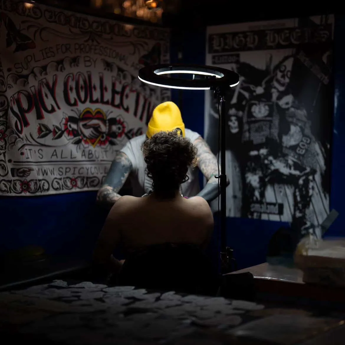 Victor från High Heels Tattoo tatuerar på mässa med Spicy Collective-banner i bakgrunden