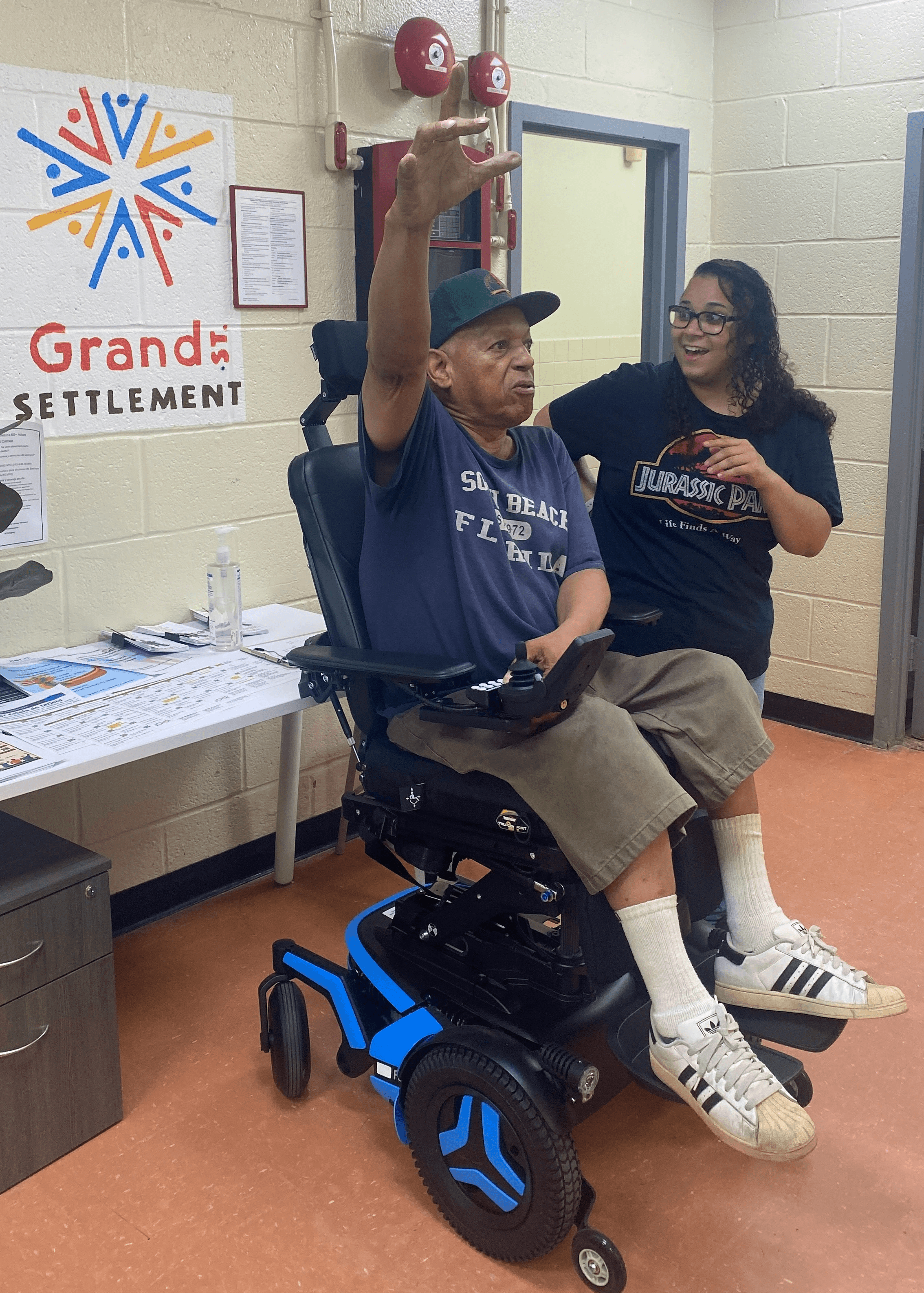 A participant and his health coach triumphantly show off his new motorized wheelchair.
