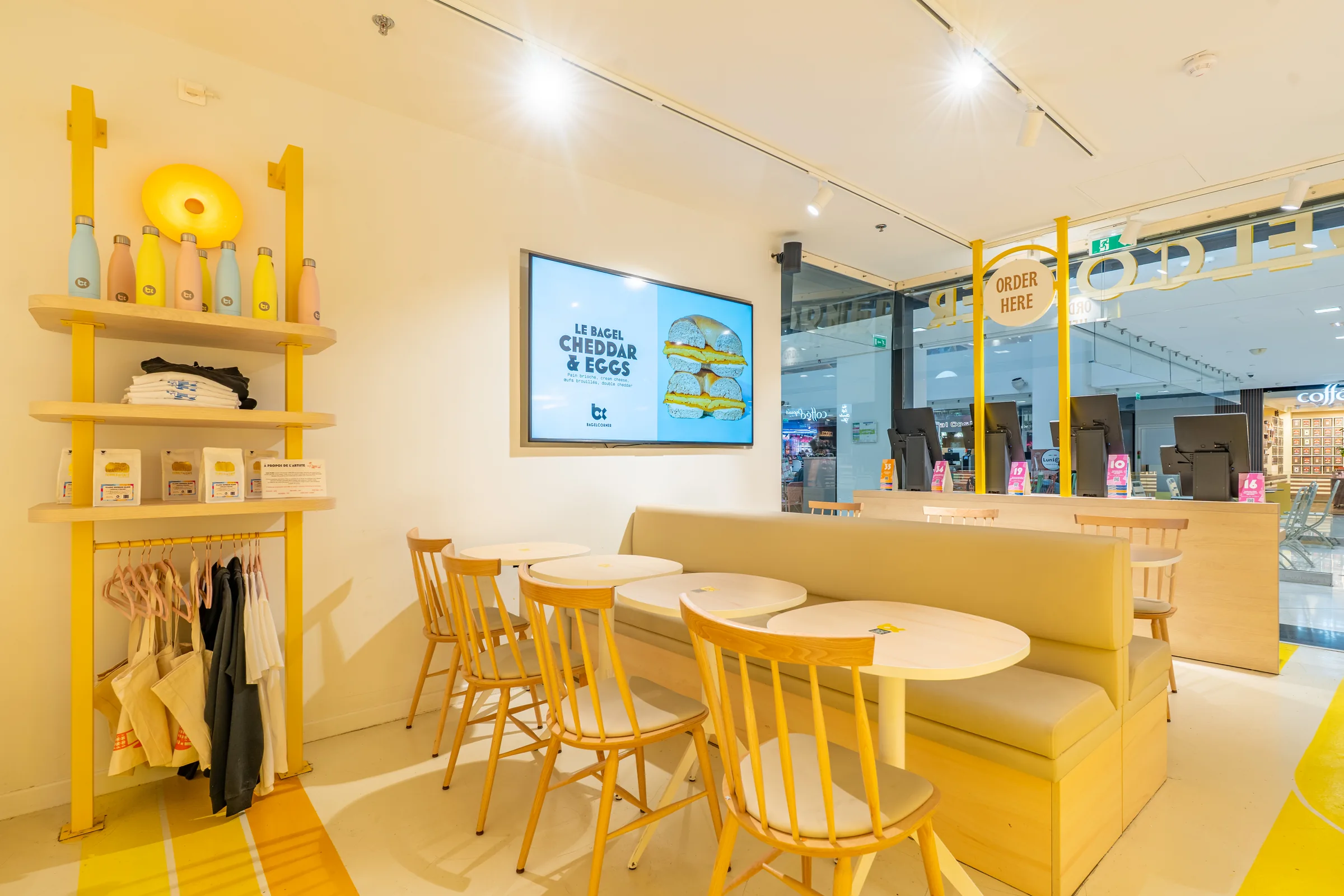 Yellow dining area at Bagel Corner Nice — Nice, France. Photography by Yunes Calore.