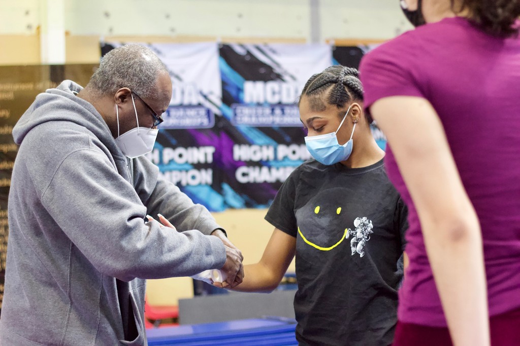 Coach Roger taping students wrist before their pass