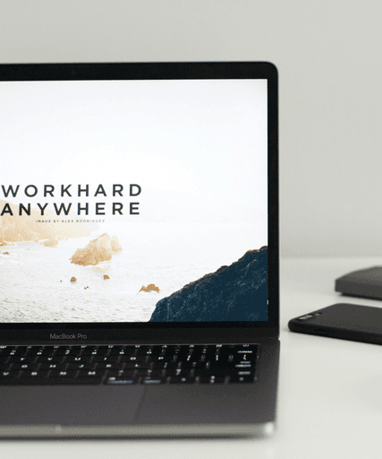 MacBook Pro near green potted plant on table