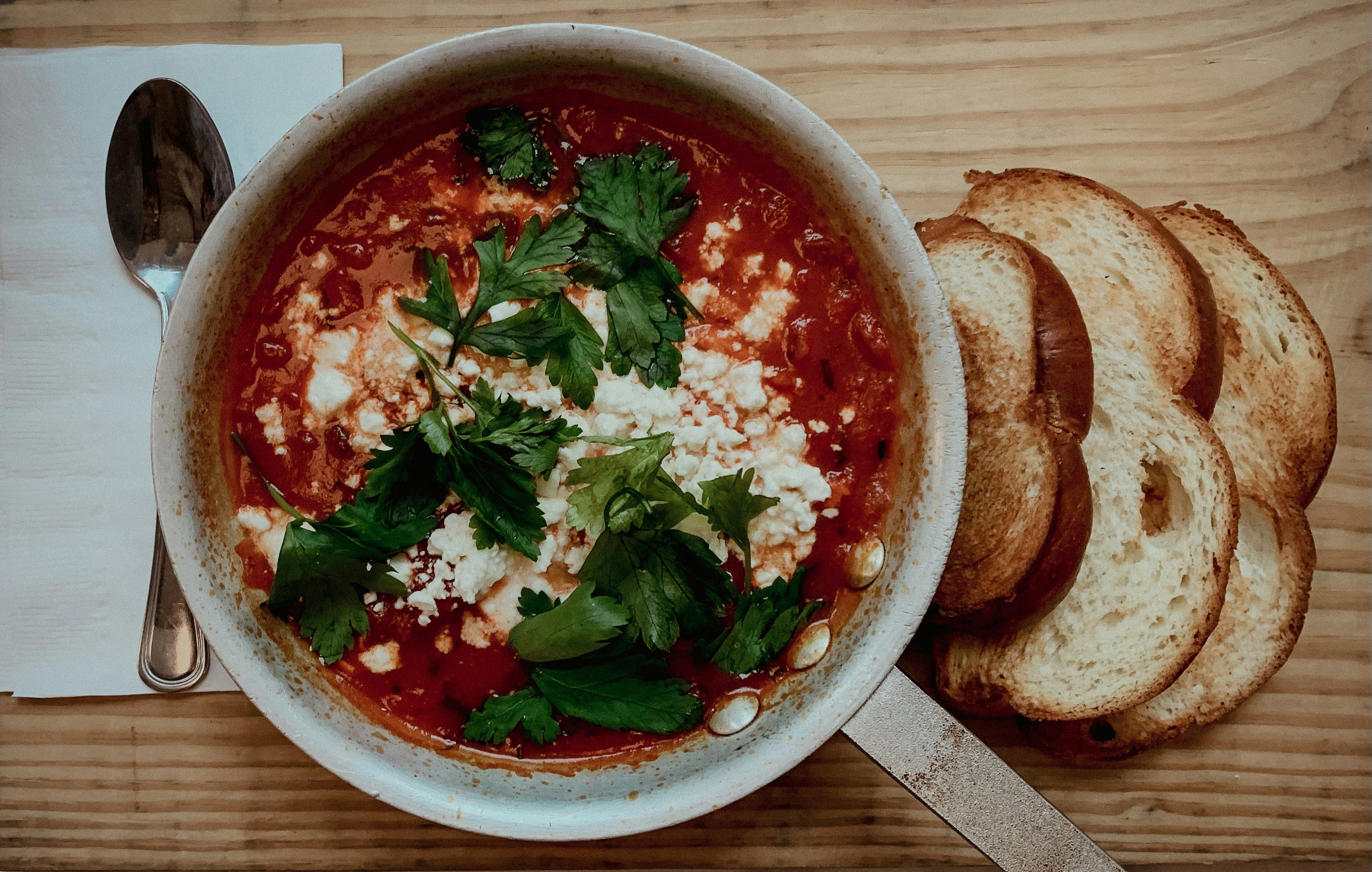 a bowl of soup with bread on a table