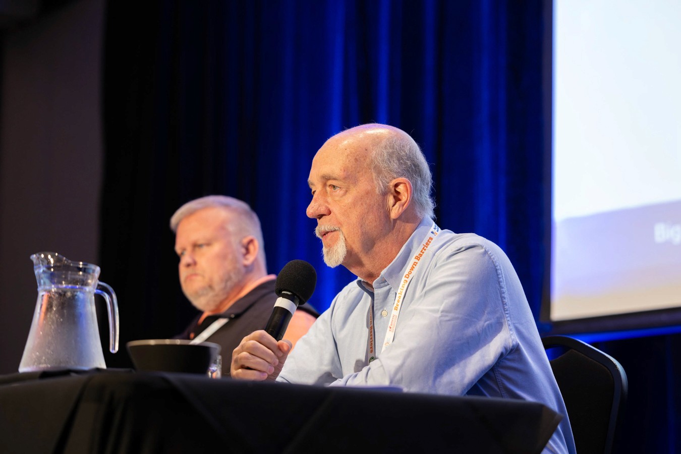 Man presenting into micophone at conference