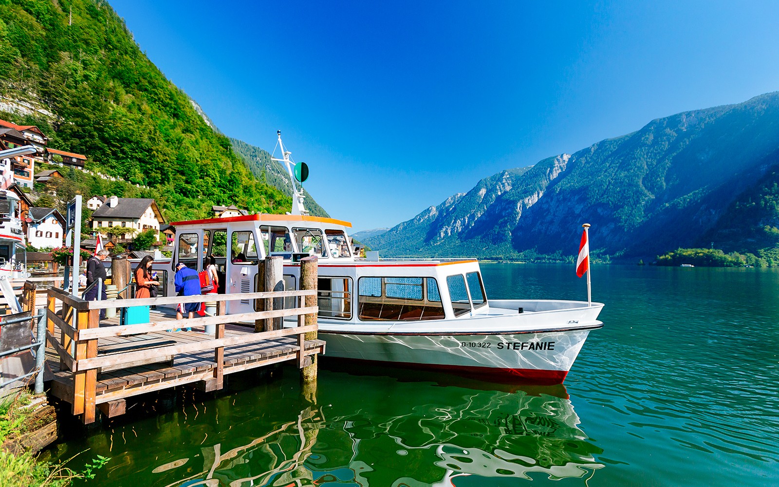 Boat docked at Hallstatt lake with mountains in the background, part of Vienna day trip.