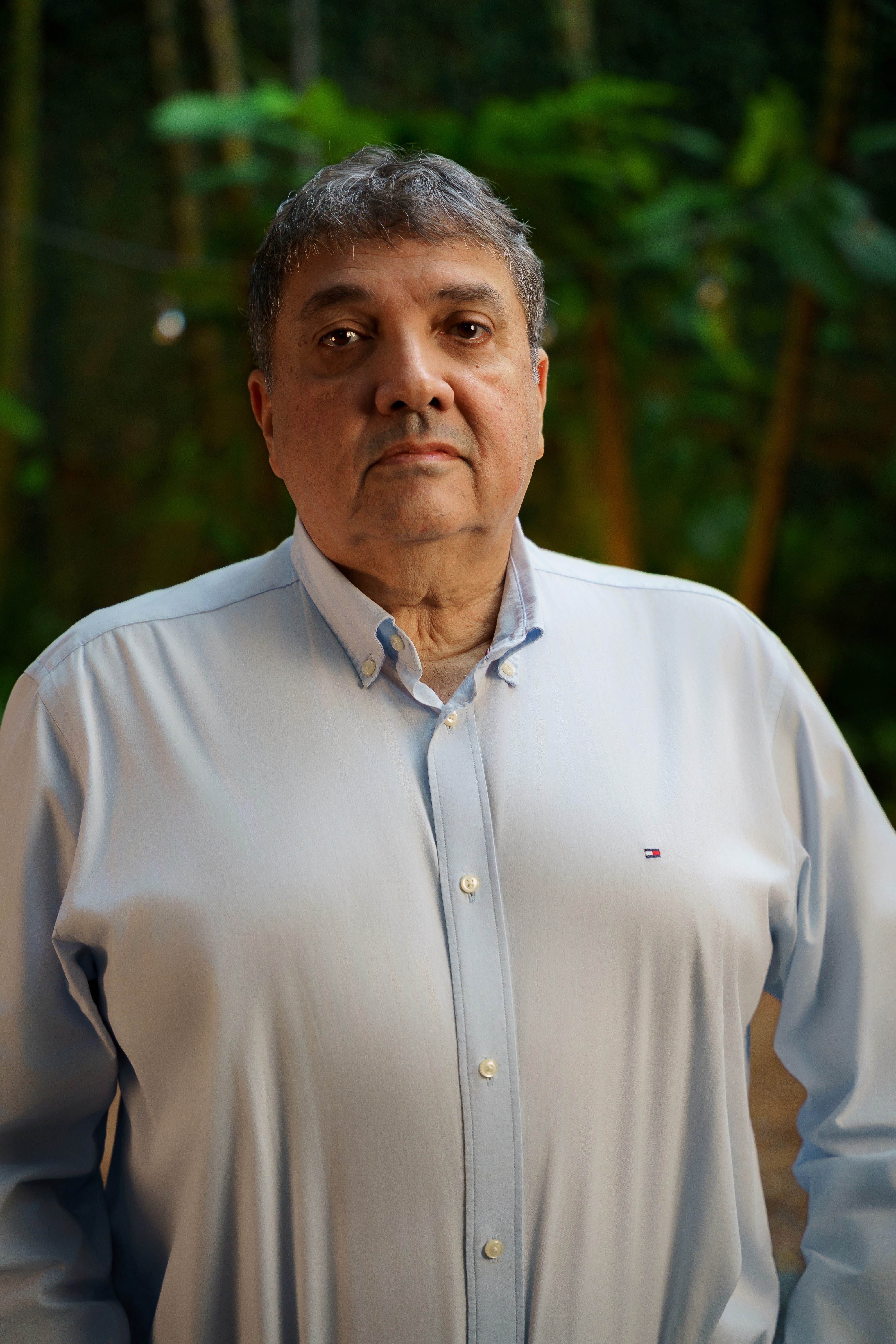 Imagem com Dr. Claudio psiquiatra olhando para a camera em fundo verde