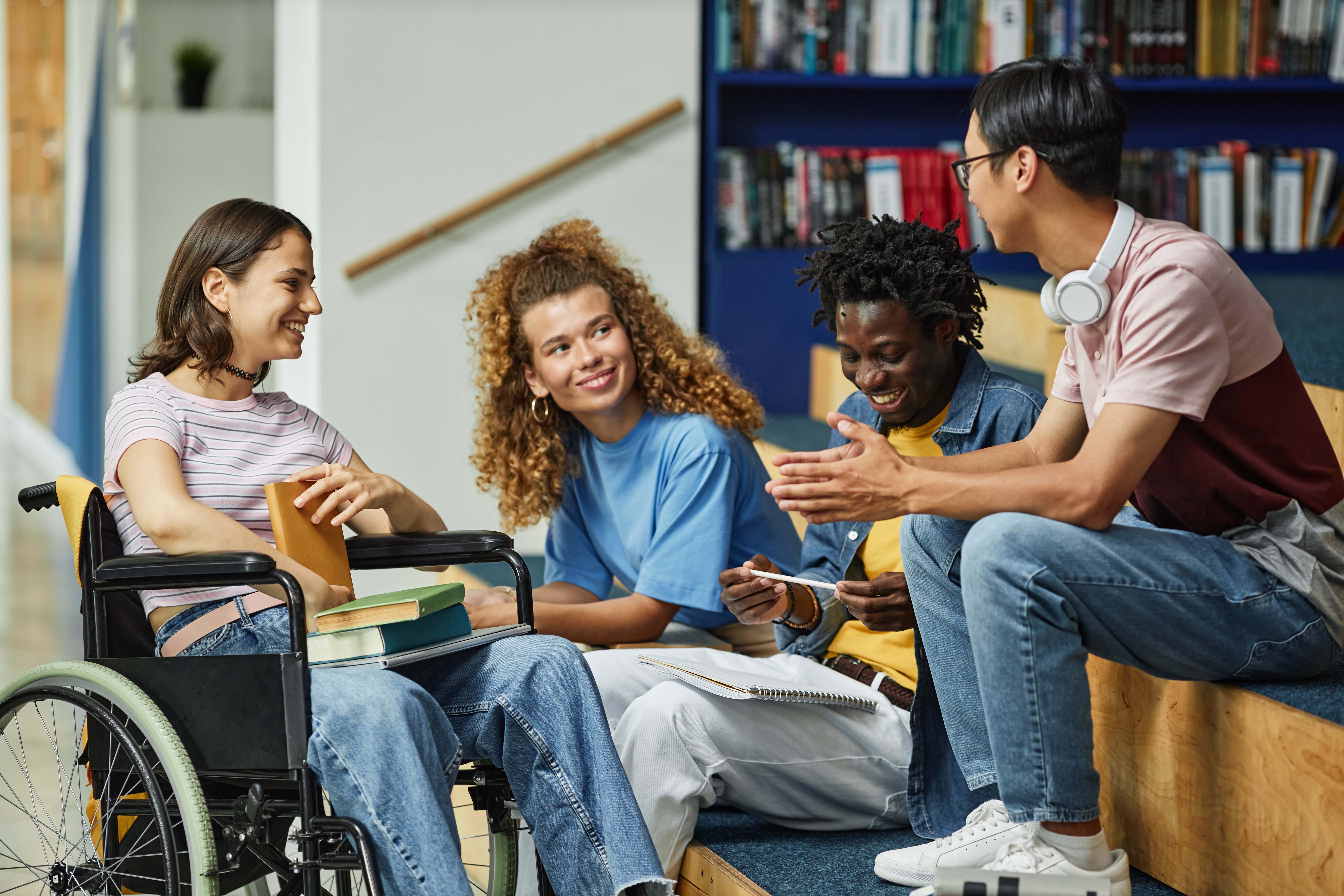 Diverse group of four people. One is in a wheelchair