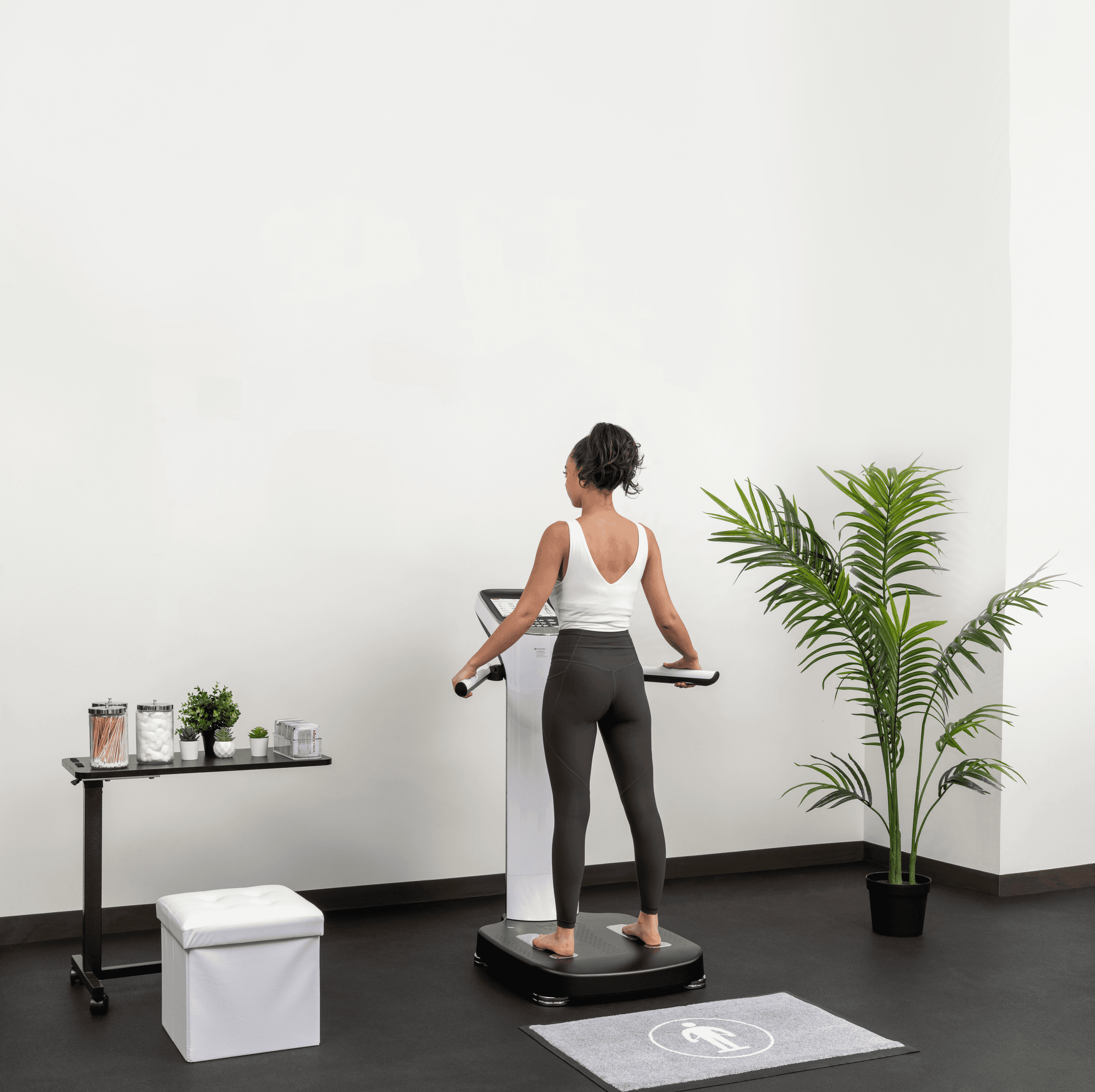 Woman standing on an InBody body composition analyzer to measure skeletal muscle mass and body fat percentage.