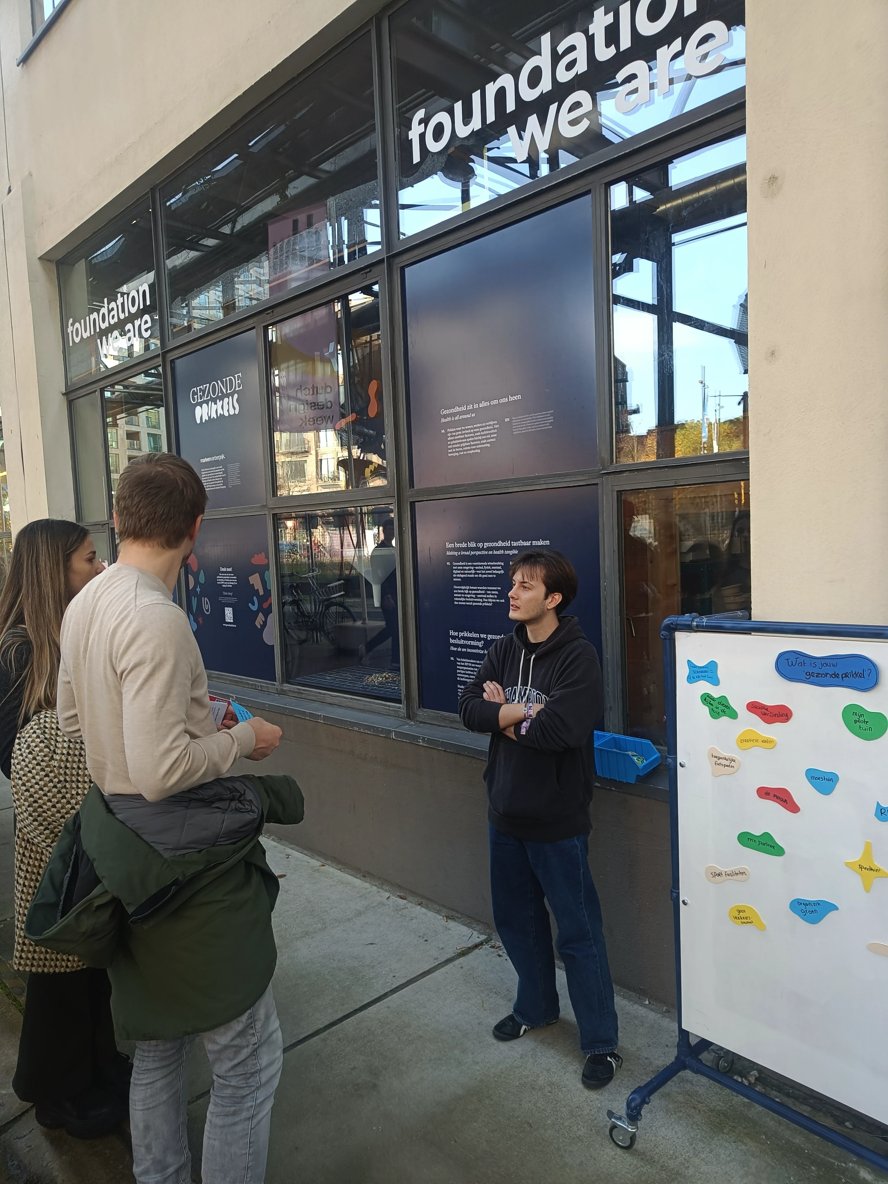 Visitors talking in front of the Gezonde Prikkels installation windows