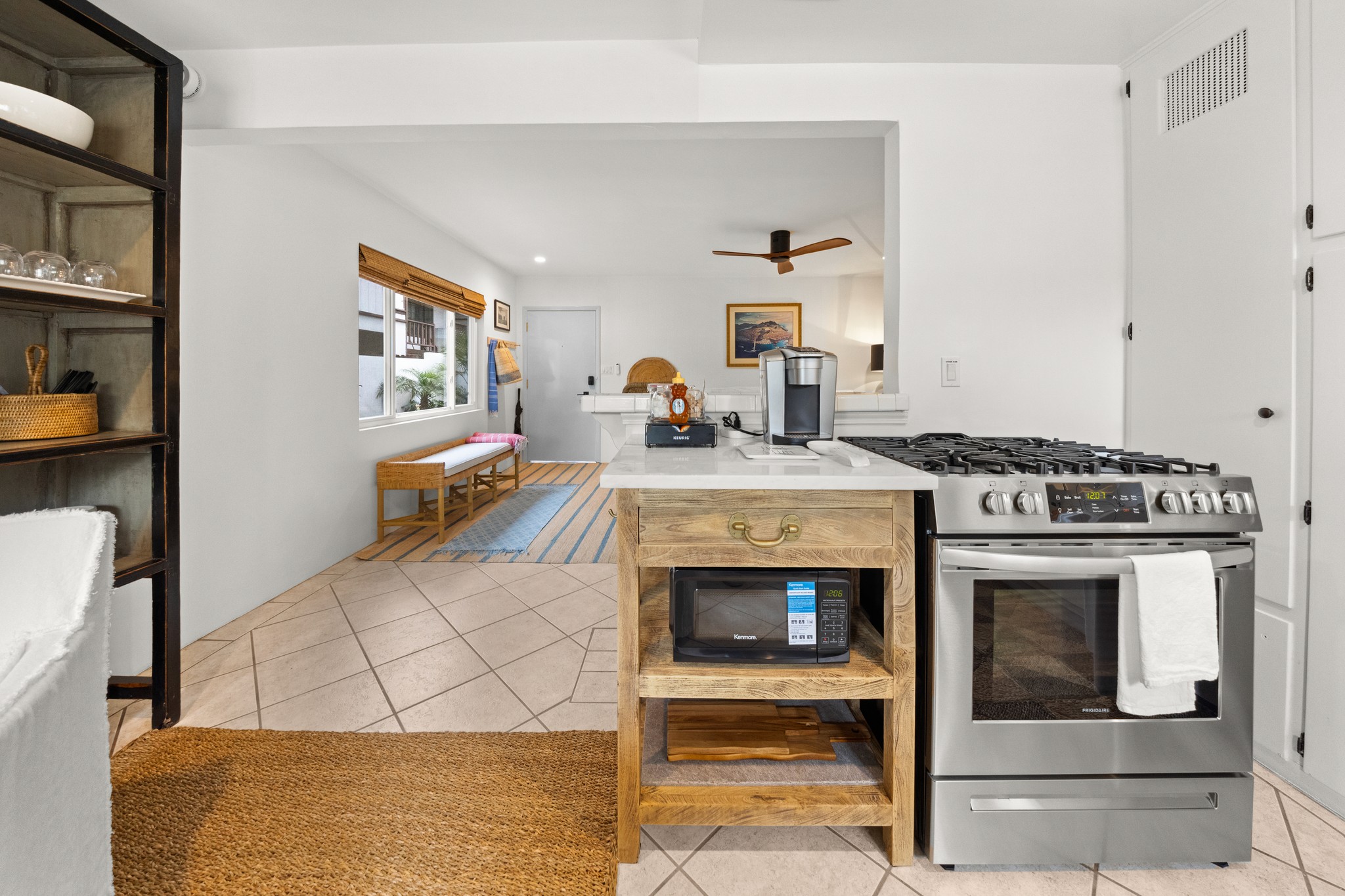 Bright, fully equipped kitchen with modern appliances and an open flow toward the welcoming entry and living area.