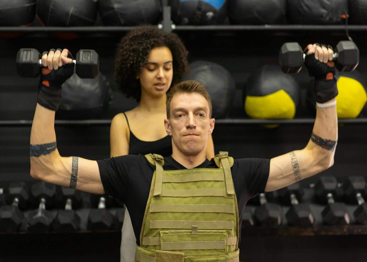 Man working out in a gym with two dumbbells