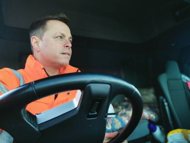 image of the inside of a lorry cab with the driver wearing a high vis jacket