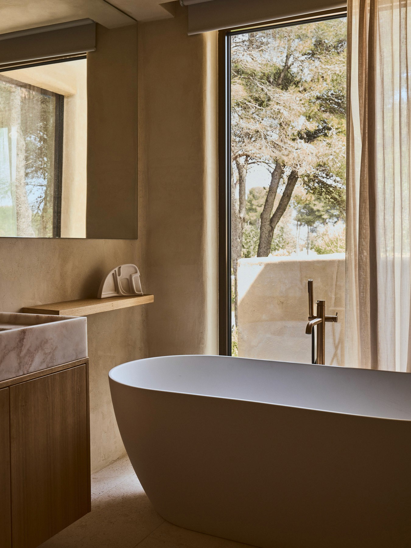 Contemporary bathroom with freestanding bathtub, oak joinery and views to nature.