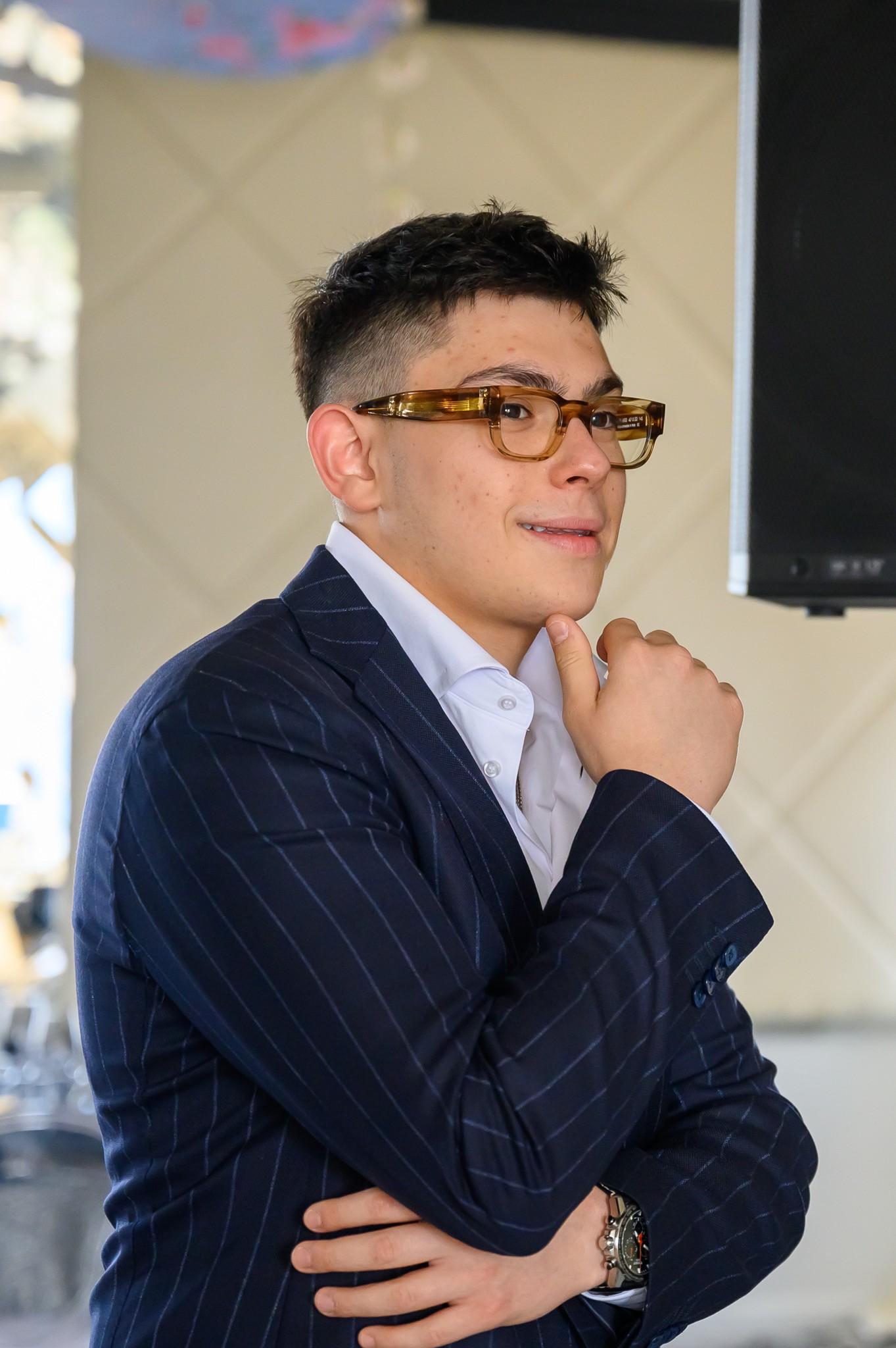 a man wearing glasses and a blazer