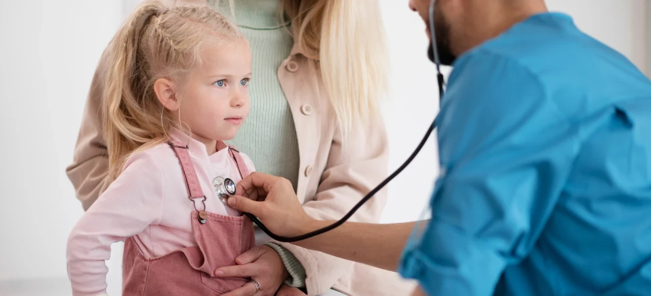 Doctor listening to a young girl’s chest with a stethoscope