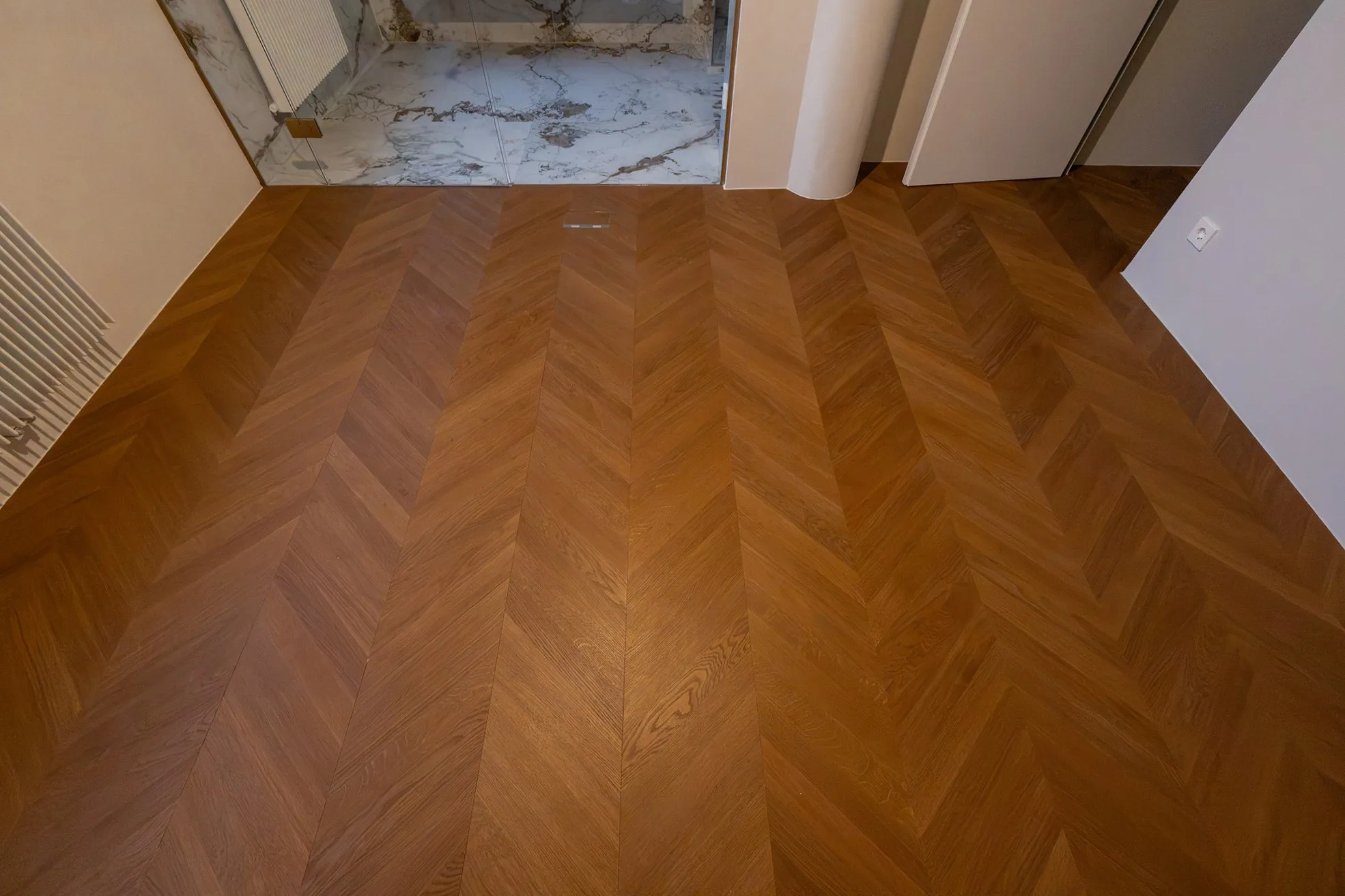 Innenraum mit präzise verlegtem Chevron-Parkettboden und sauber ausgearbeiteten Übergängen