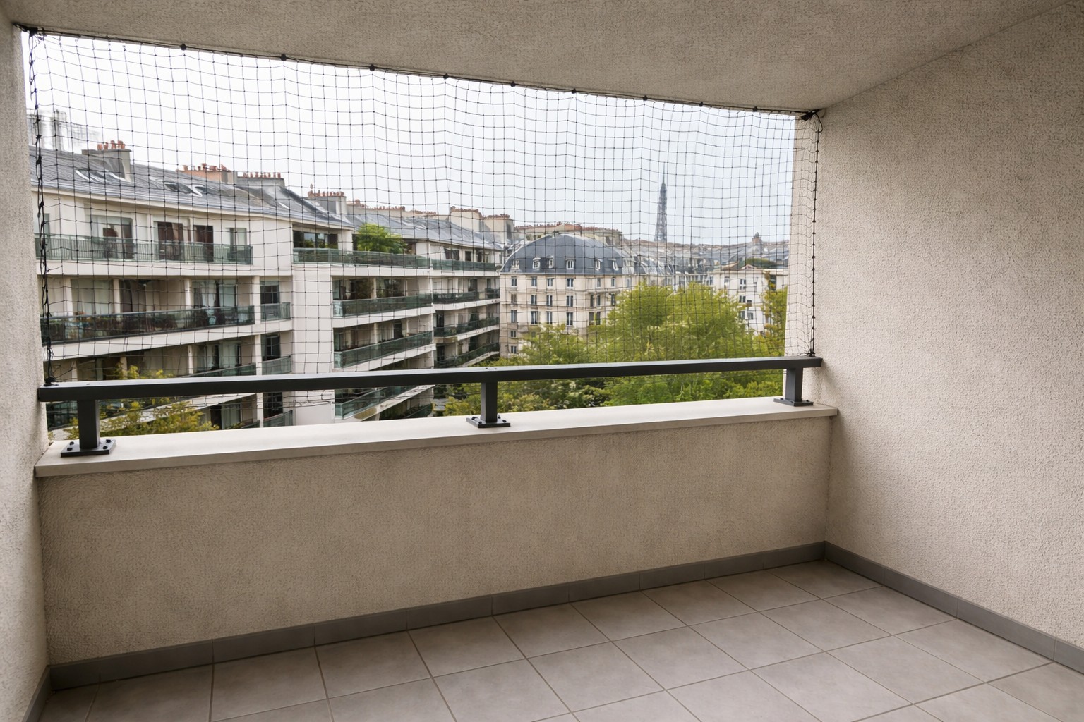 Filet anti pigeon installé sur un balcon d’immeuble en copropriété à Paris, vue urbaine avec immeubles en arrière-plan
