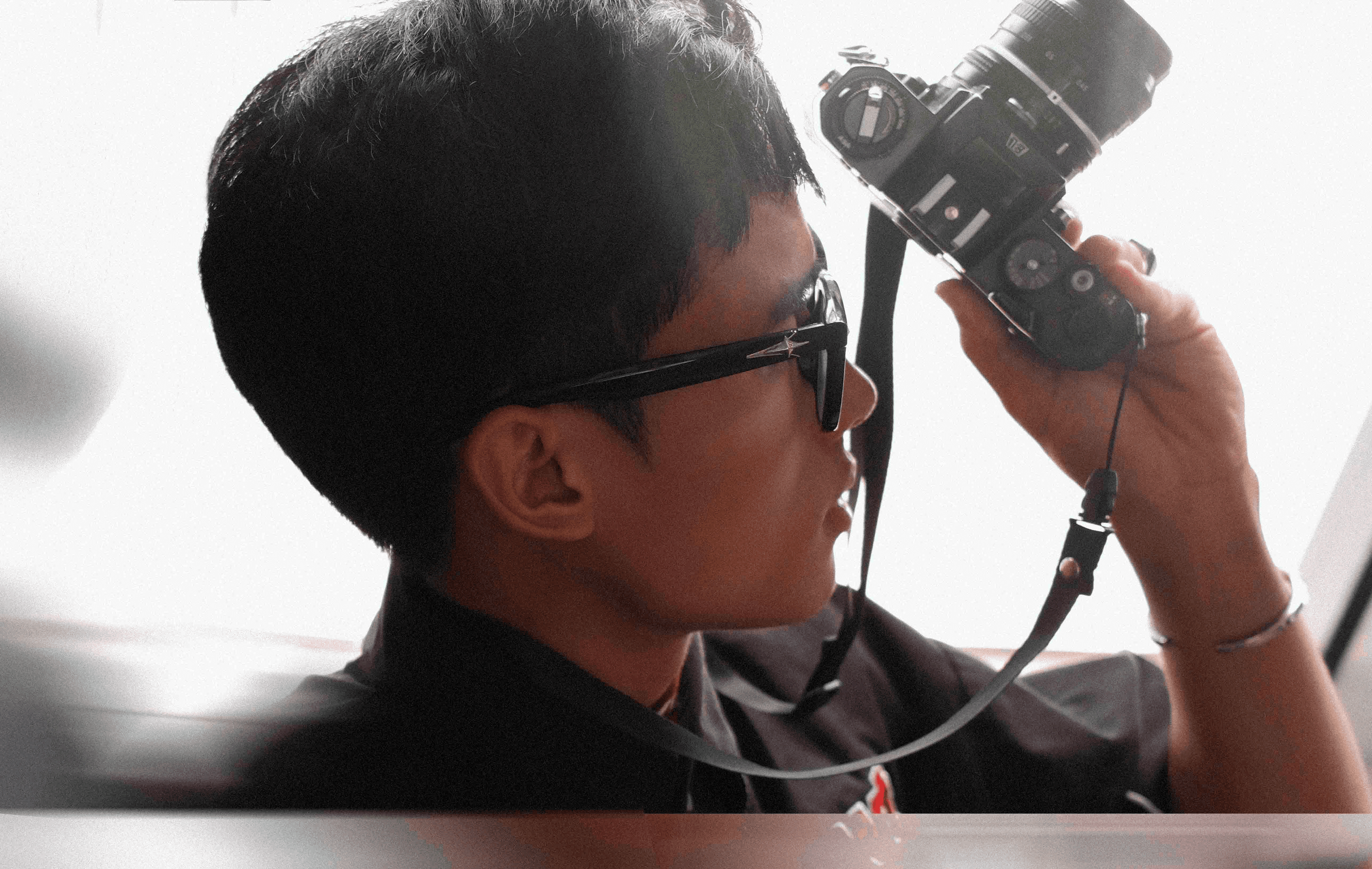 Silhouette of a person using a camera. Photographer taking photos with a professional DSLR camera in low light setting.