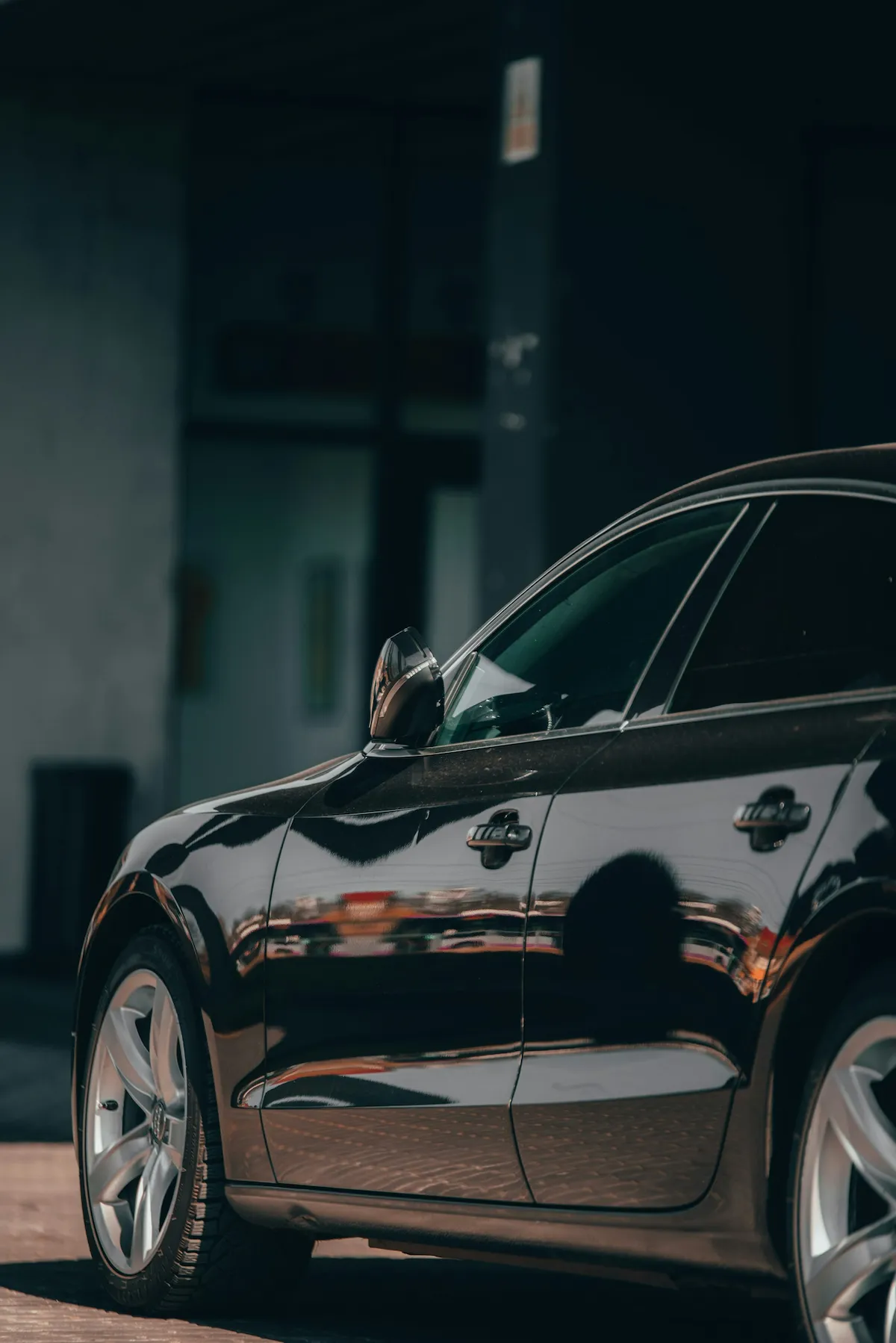 Paint Enhancement - Side view of a shiny black car with glossy paint