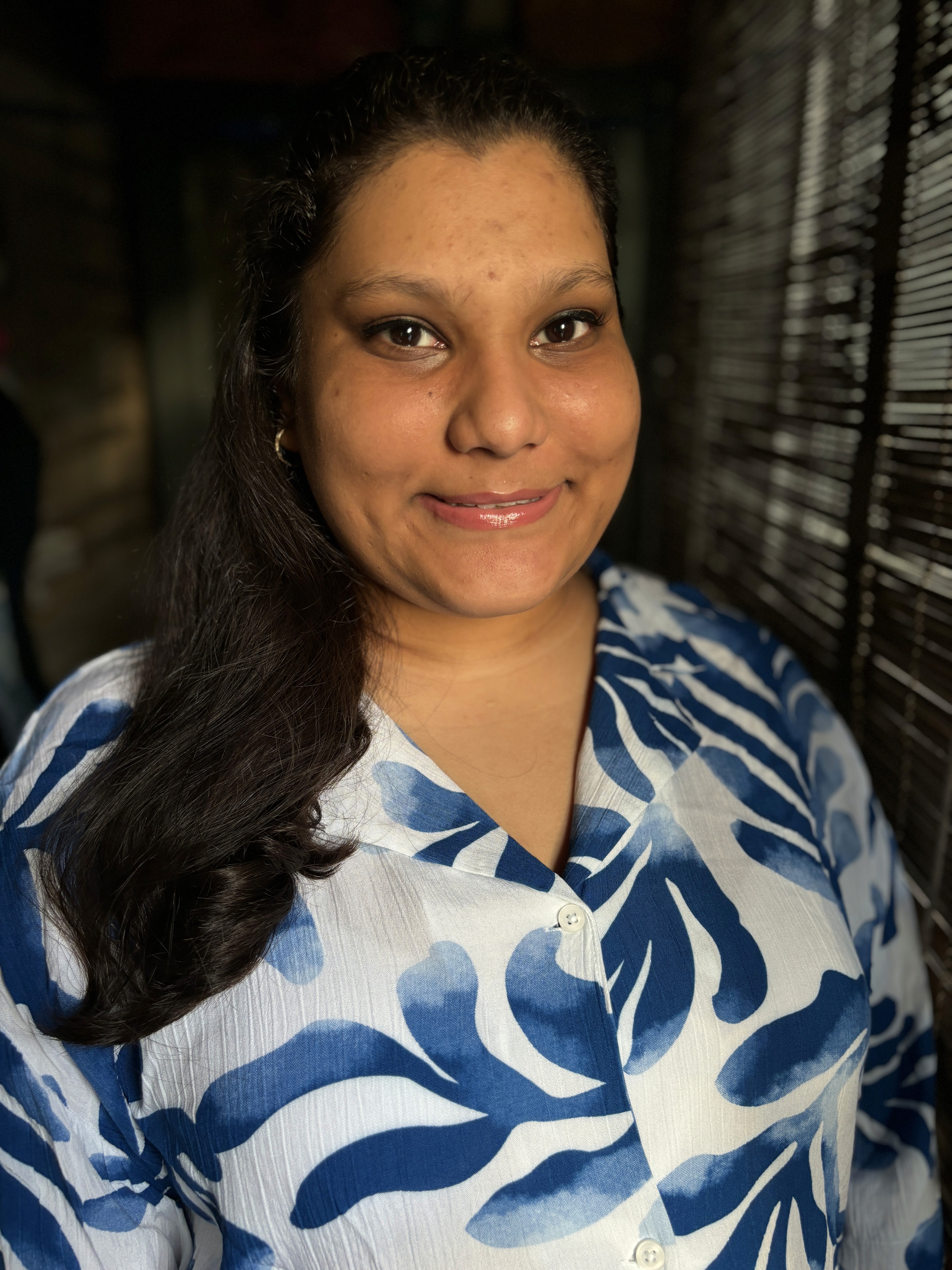 A thoughtful young person with dark hair gazes to the side, captured in soft black and white lighting.