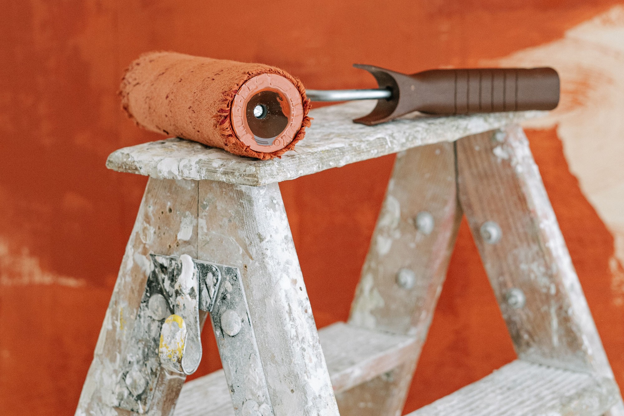 Website redesign planning concept with a paint roller, used for deciding whether redesign or SEO should come first
