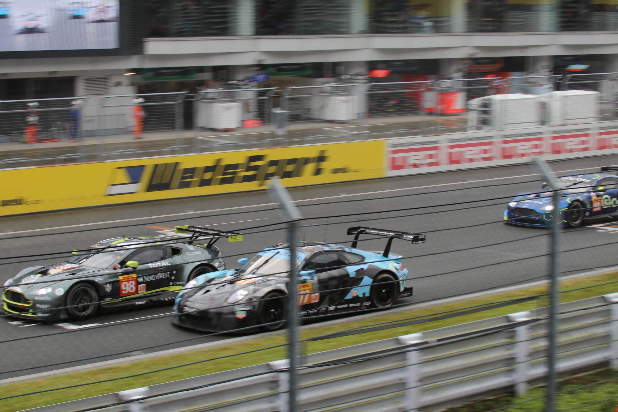 A blue lamborghini driving on a race track.