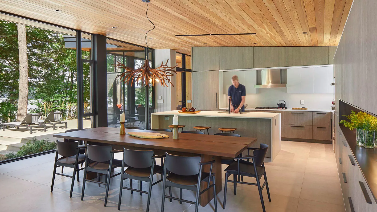 high end luxury cottage kitchen and dining room with modern finishes and artistic wood chandelier.