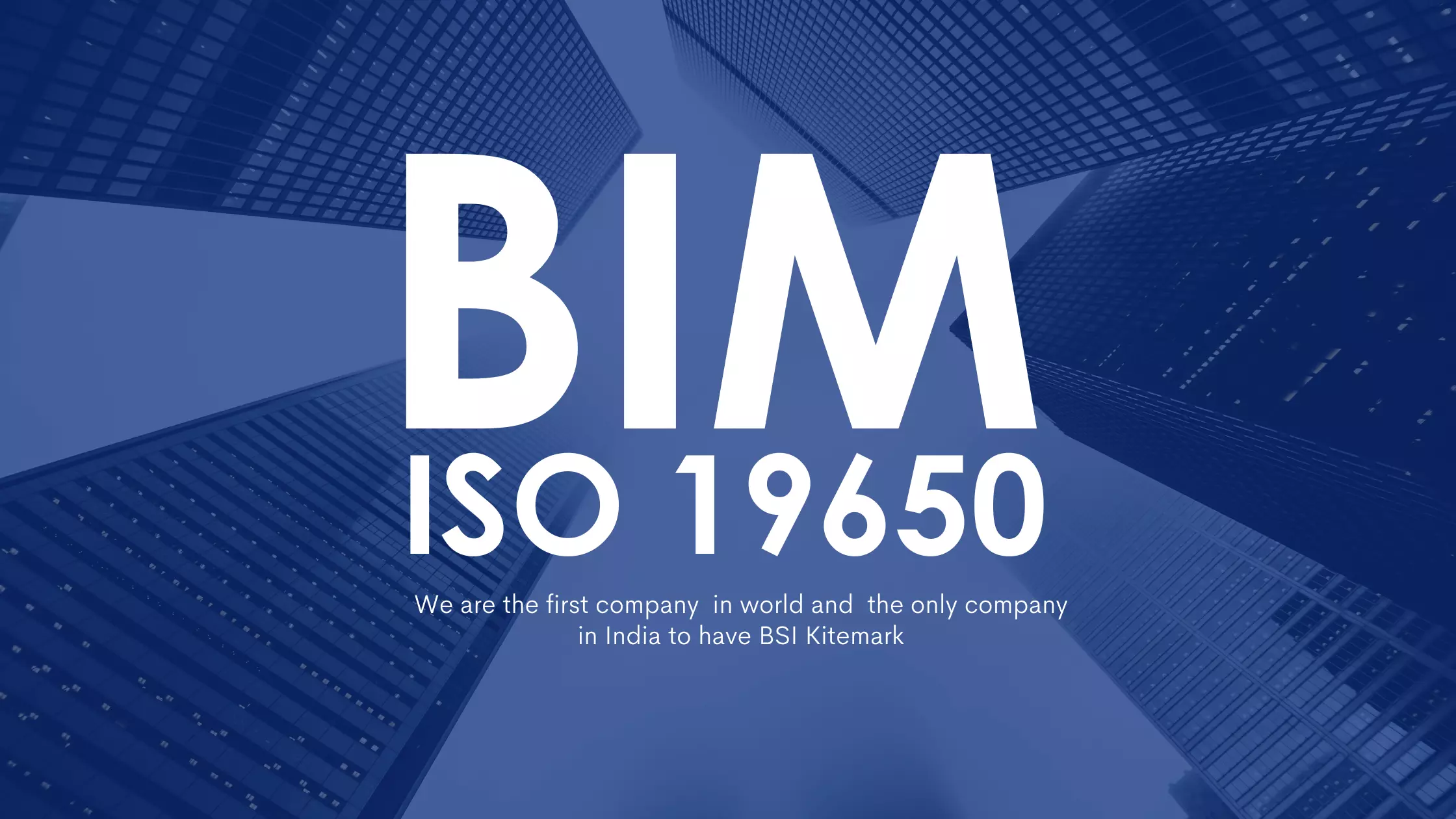 A man stands while two people sit at a table in an office setting, smiling and engaged in conversation. The mood is friendly and collaborative.