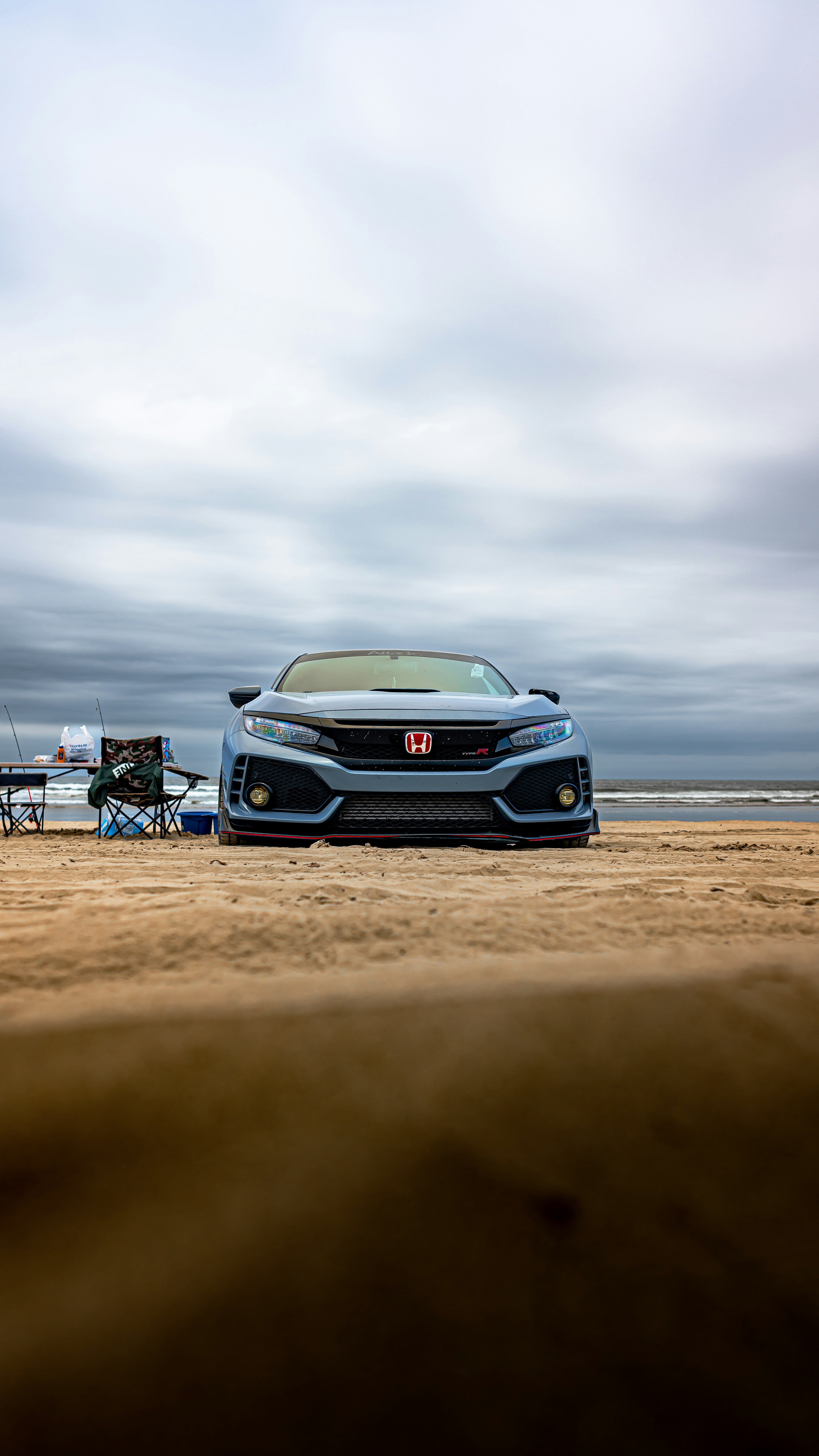a car parked on a beach next to a picnic table