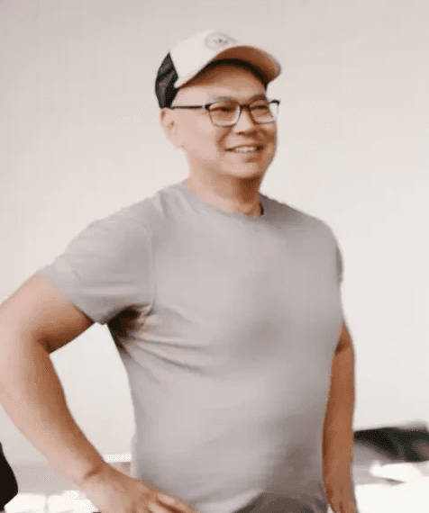 Profile portrait of a man in a white shirt against a light background