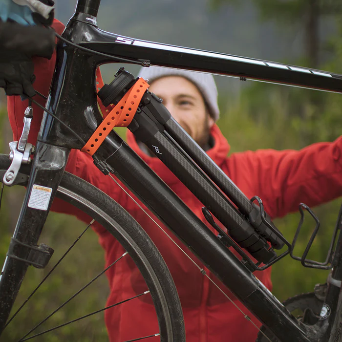 Man holding bike with tripod strapped on