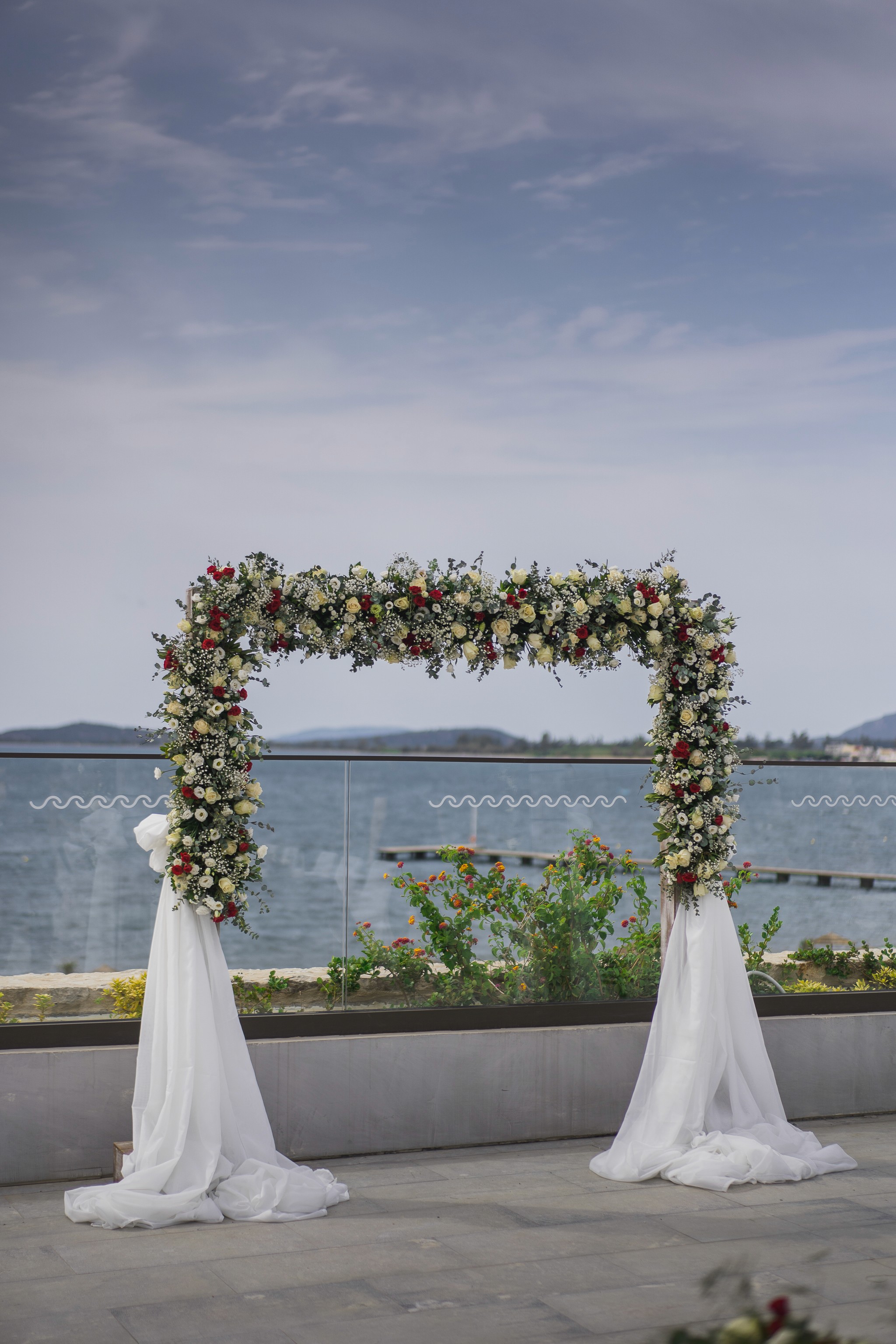 Elegant floral arch with white drapes for a coastal civil wedding ceremony in Costa Navarino Greece