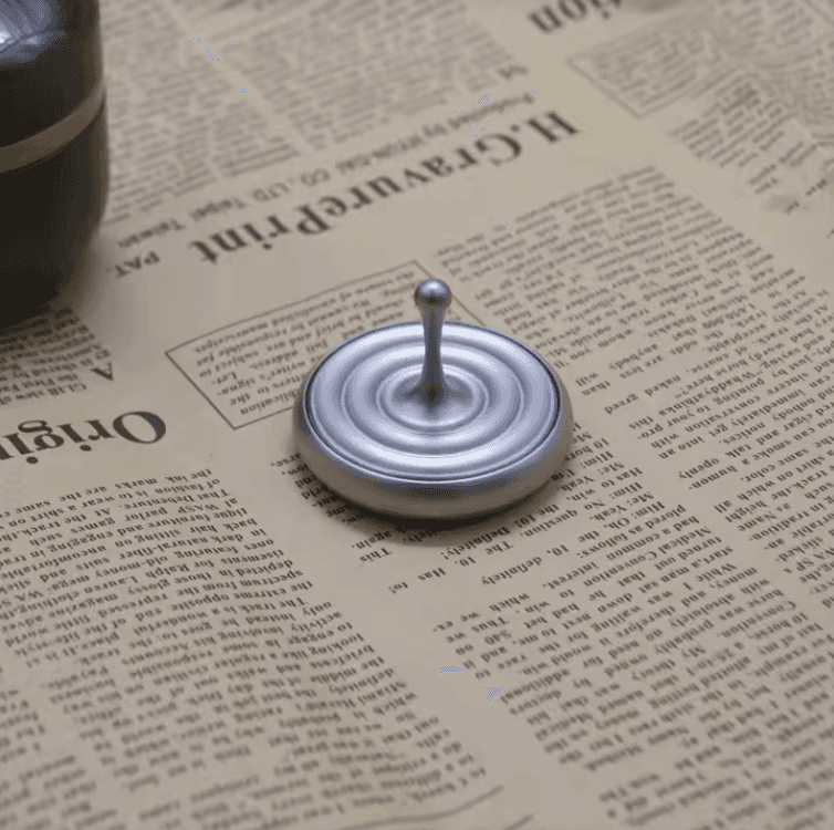 Minimal metal balance spinning object with reflective surface on desk