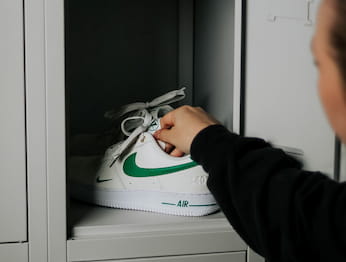Eine Hand die Nike Air Force aus dem Regal holt. Nike Werbe Foto