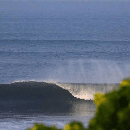 A large wave crashing on the shore - surfboard rental in el-sunzal.