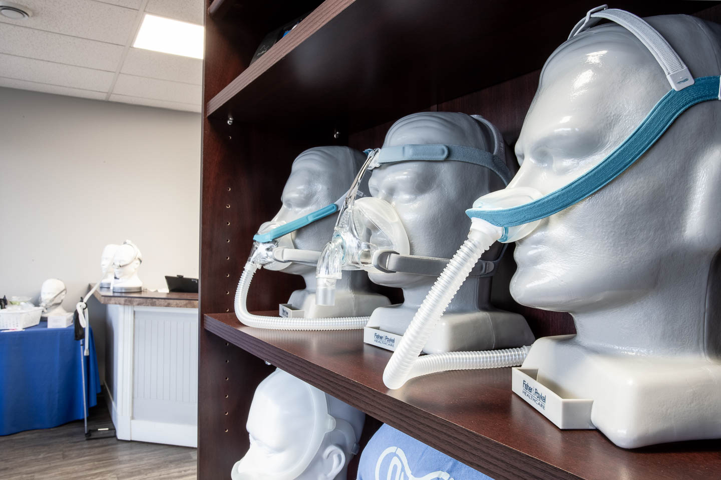 Close up of CPAP machines on busts sitting on a shelf in a clinic reception area